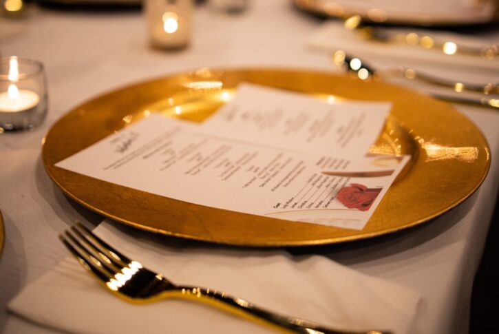 Gala Dinner Setting a plate with a menu, fork and napkin, and candlelight